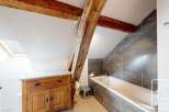 Discover the charm of this unique bathroom featuring exposed wooden beams and a stylish design.