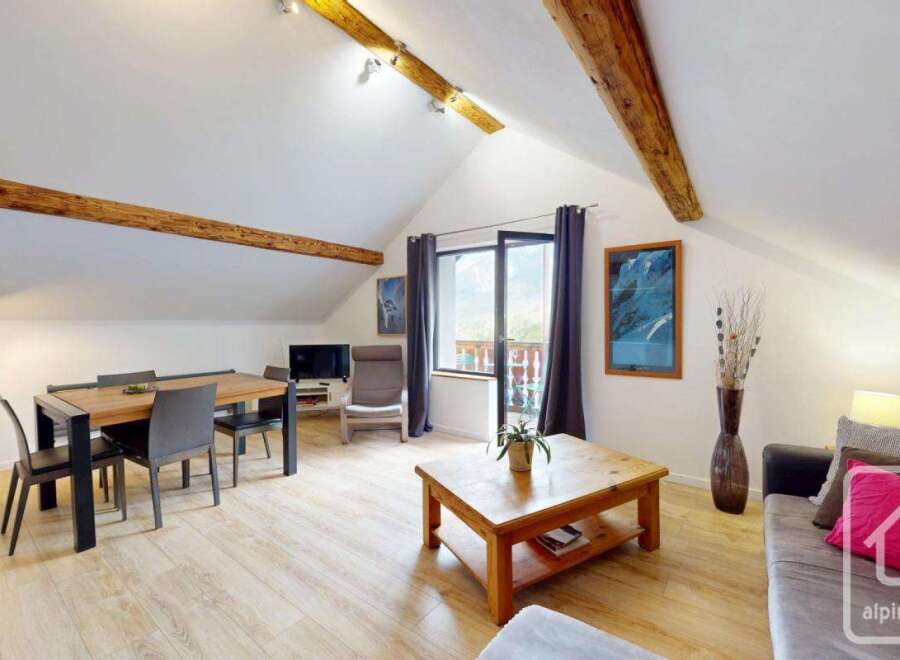 Discover the charm of this stunning property, featuring a spacious living area with exposed wooden beams and a modern design.