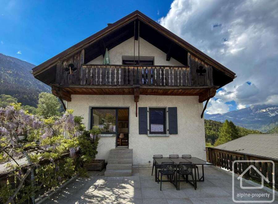Discover the charm of this stunning alpine property, boasting a traditional wooden balcony and breathtaking mountain views.