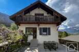 Discover the charm of this stunning alpine property, boasting a traditional wooden balcony and breathtaking mountain views.