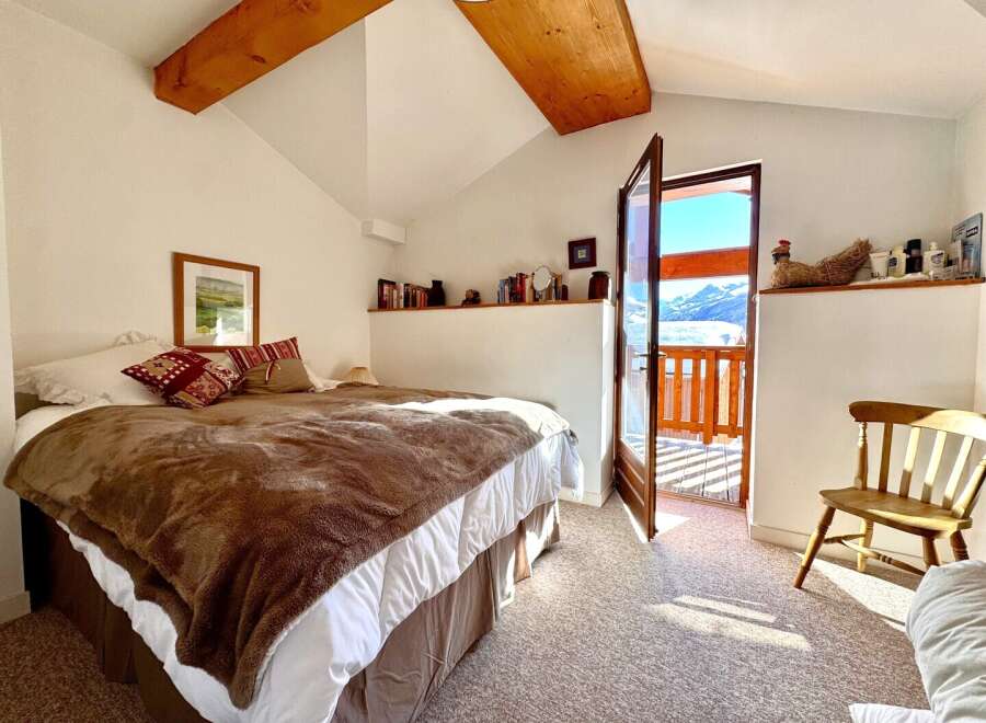 This charming bedroom offers a cozy retreat with stunning mountain views.