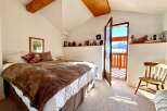 This charming bedroom offers a cozy retreat with stunning mountain views.