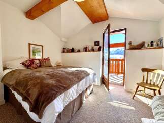 This charming bedroom offers a cozy retreat with stunning mountain views.
