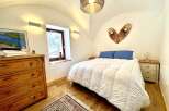 This charming bedroom boasts a cozy ambiance with its inviting bed and unique decor.