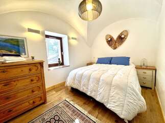 This charming bedroom boasts a cozy ambiance with its inviting bed and unique decor.
