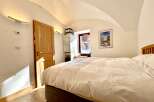 This cozy bedroom features a comfortable bed with a pristine white duvet, perfect for a relaxing retreat.