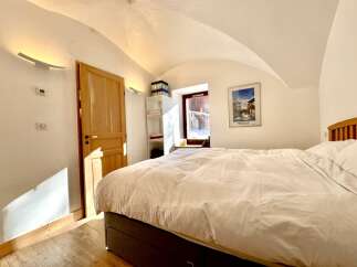 This cozy bedroom features a comfortable bed with a pristine white duvet, perfect for a relaxing retreat.
