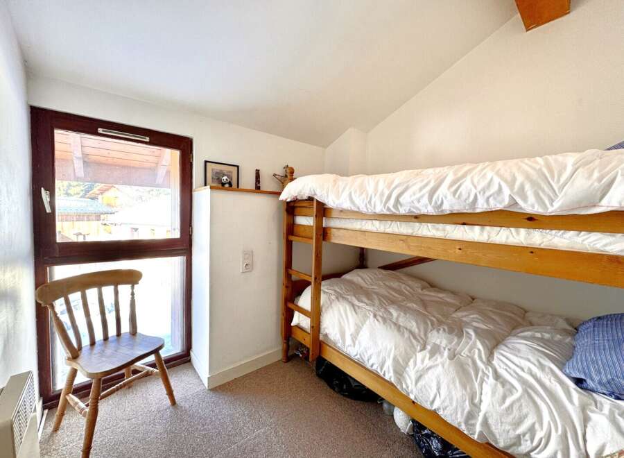 This cozy bedroom features a charming wooden bunk bed, perfect for accommodating guests or family members.