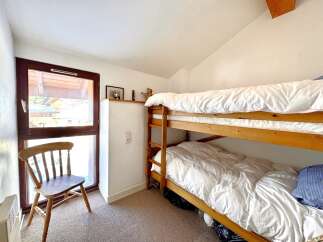 This cozy bedroom features a charming wooden bunk bed, perfect for accommodating guests or family members.
