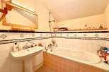 This charming bathroom features a classic design with a pedestal sink and a bathtub.