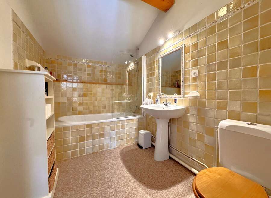 Step into this charming bathroom, featuring a classic design with tiled walls and a cozy atmosphere.