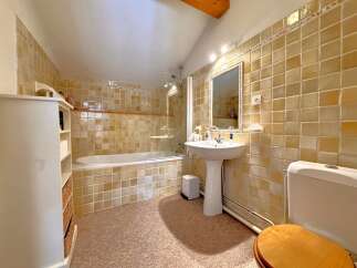 Step into this charming bathroom, featuring a classic design with tiled walls and a cozy atmosphere.