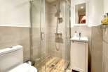 Step into this modern bathroom featuring a sleek glass shower enclosure, perfect for a refreshing start to your day.