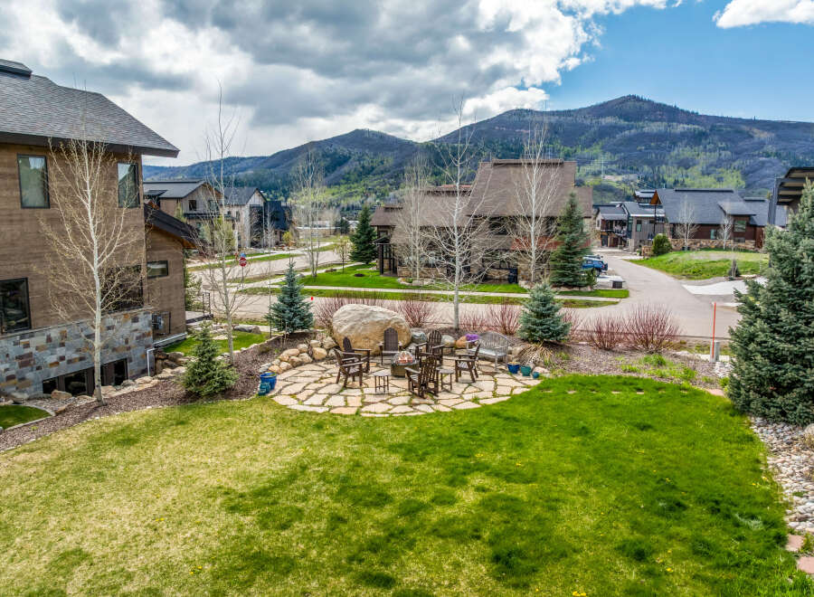 Discover luxury living in this stunning property, featuring a beautifully landscaped yard and a cozy outdoor seating area perfect for entertaining.