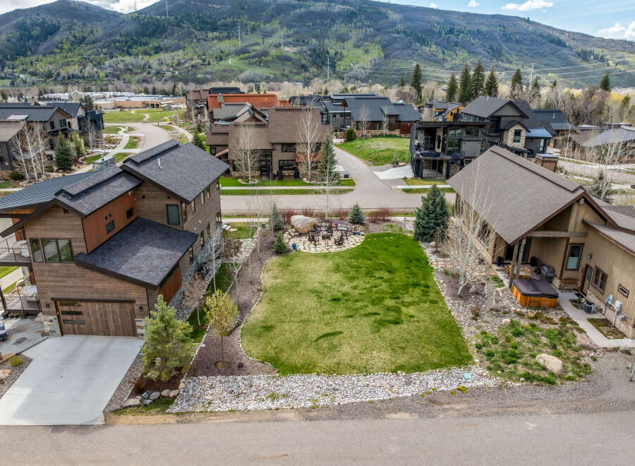 Discover luxury living in this stunning property featuring a meticulously landscaped yard and a cozy fire pit area, perfect for entertaining.