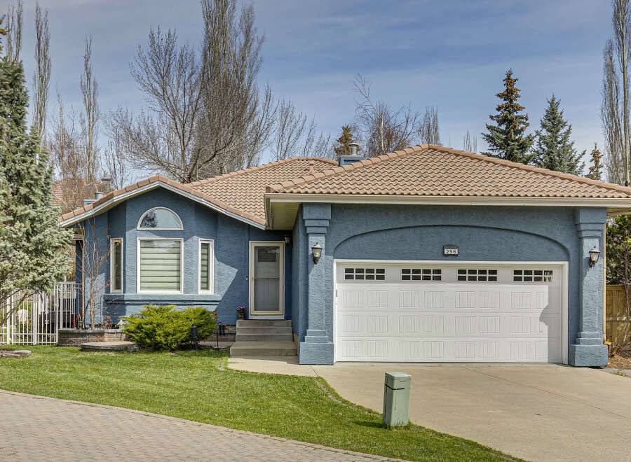 This charming home boasts a beautiful exterior with a blue stucco finish and a terracotta tile roof.