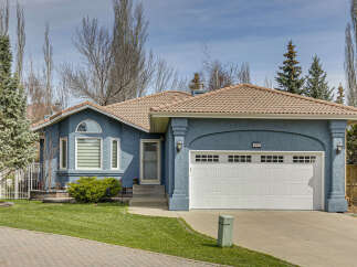This charming home boasts a beautiful exterior with a blue stucco finish and a terracotta tile roof.
