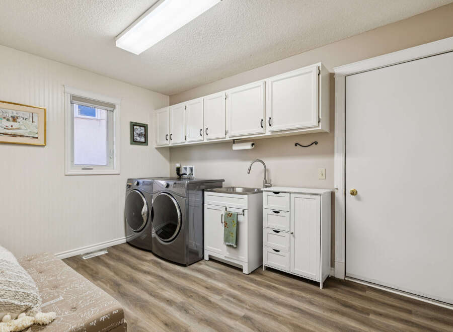 This laundry room offers a bright and functional space with ample storage and modern appliances.