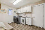 This laundry room offers a bright and functional space with ample storage and modern appliances.