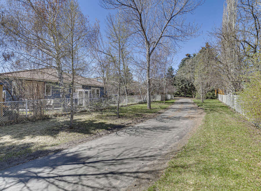 Discover the charm of this property, featuring a serene pathway leading to a cozy home.