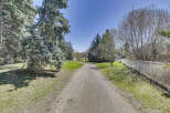Discover the tranquility of this property, featuring a serene pathway winding through lush greenery.