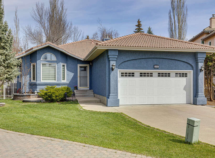 This charming home boasts a beautiful facade with a blue exterior and a welcoming front yard.