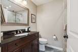 This stunning bathroom boasts a sleek, modern design with a dark wood vanity and a contrasting black countertop.