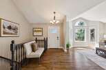 Step into this inviting entryway, showcasing beautiful hardwood floors and a welcoming bench.