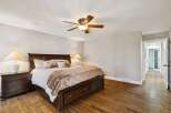 Step into luxury with this stunning bedroom featuring a grand, dark wood bed frame and matching nightstands.