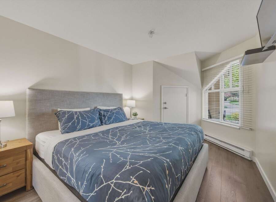 This inviting bedroom features a comfortable bed with a stylish blue patterned duvet and matching pillows, creating a serene atmosphere.