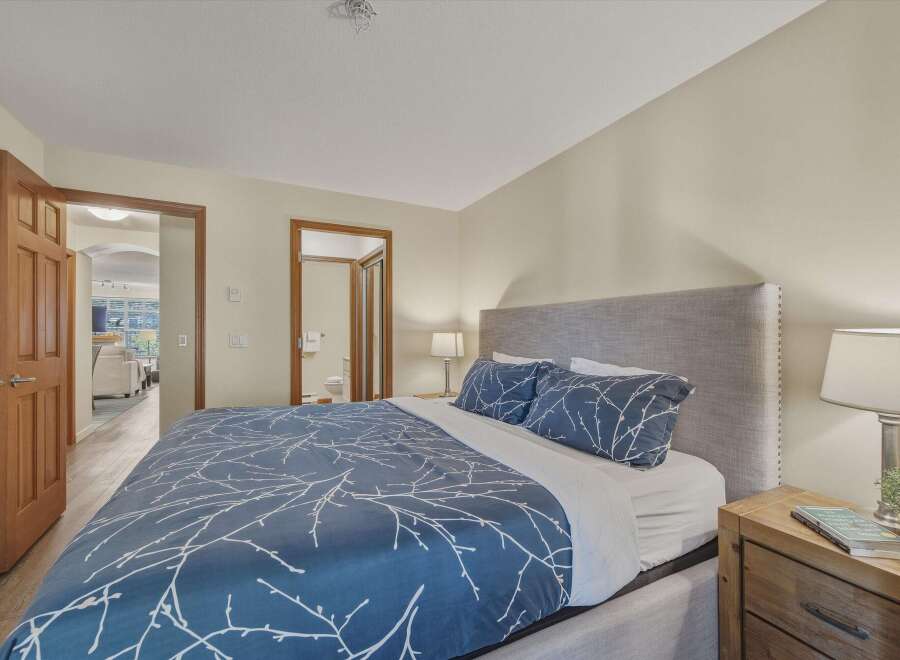 Step into this inviting bedroom, featuring a comfortable bed with stylish blue bedding and a cozy headboard.