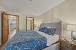 Step into this inviting bedroom, featuring a comfortable bed with stylish blue bedding and a cozy headboard.