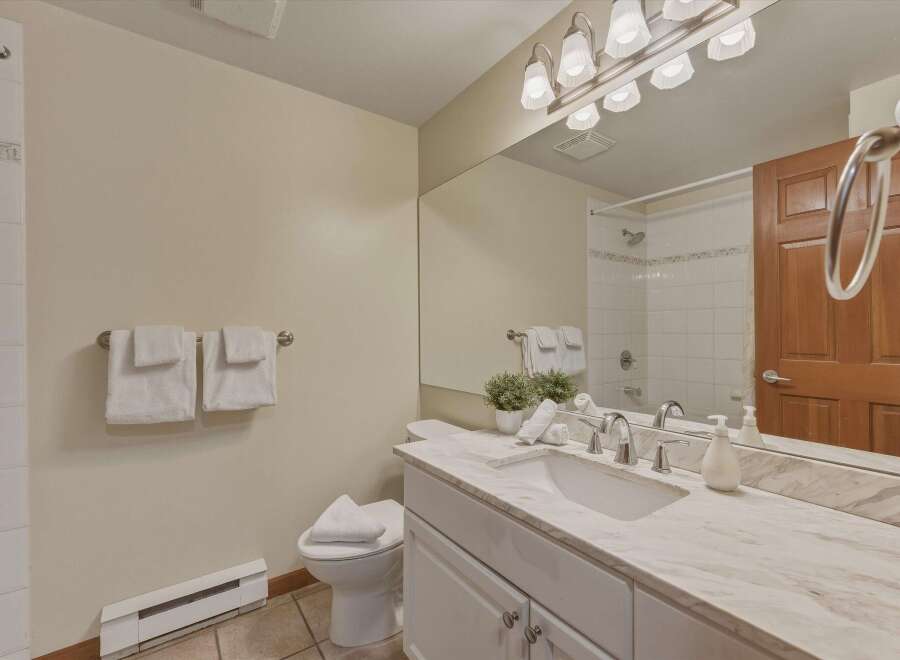This beautiful bathroom features a modern vanity with a marble countertop, providing a luxurious and stylish space.