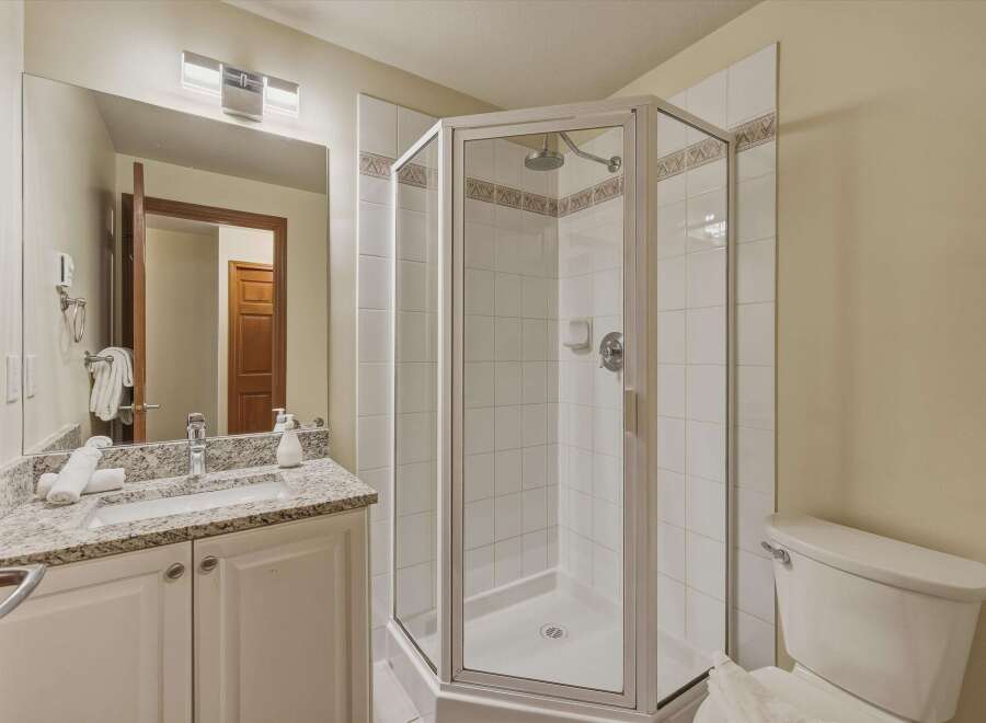 This beautiful bathroom features a modern shower with glass doors, perfect for a refreshing start to your day.