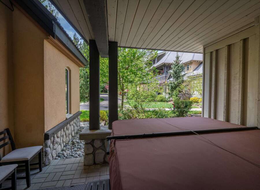 Enjoy the tranquility of this stunning property featuring a covered patio with a hot tub, perfect for relaxation.