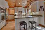 This stunning kitchen boasts a warm and inviting atmosphere with its wooden ceiling and ample natural light.