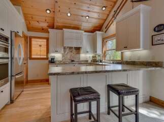 This stunning kitchen boasts a warm and inviting atmosphere with its wooden ceiling and ample natural light.