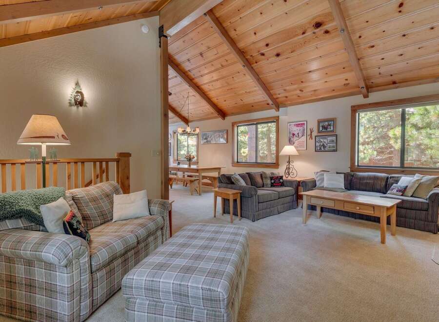 Step into this inviting living space, featuring a cozy seating area with a plaid sofa and ottoman.
