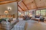 Step into this inviting living space, featuring a cozy seating area with a plaid sofa and ottoman.