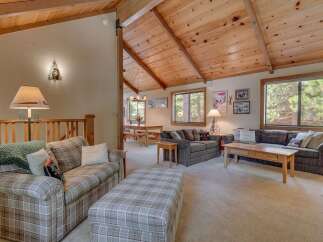 Step into this inviting living space, featuring a cozy seating area with a plaid sofa and ottoman.