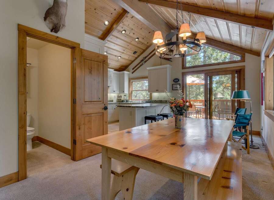 This stunning property boasts a rustic charm with its wooden vaulted ceilings and inviting dining area.