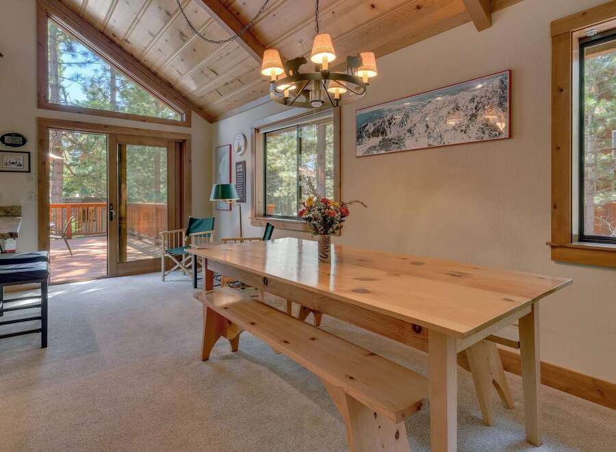 This stunning dining room features a beautiful wooden table and bench, perfect for family gatherings.