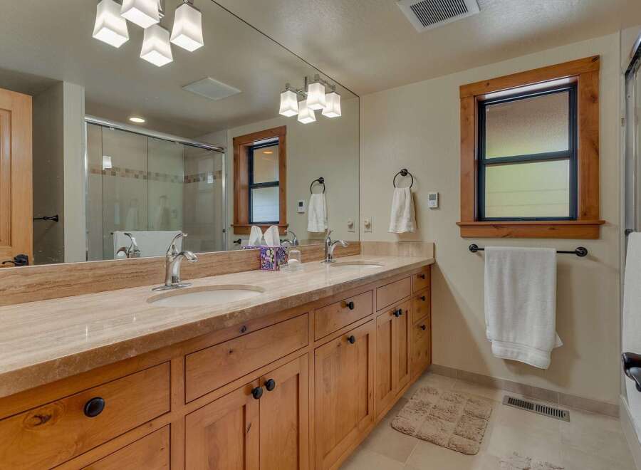 This stunning bathroom features a double vanity with a beautiful countertop and ample storage.