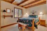 This charming bedroom features a cozy wooden bed frame and a beautiful floral comforter, creating a warm and inviting atmosphere.