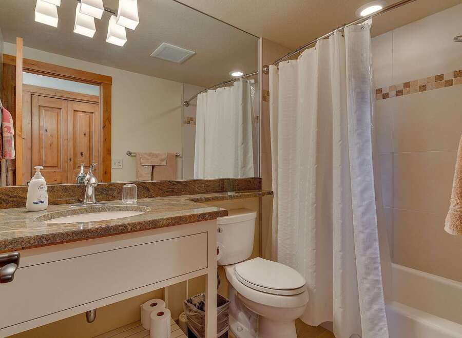 This stunning bathroom features a modern design with a spacious vanity and a beautiful granite countertop.