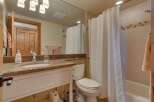 This stunning bathroom features a modern design with a spacious vanity and a beautiful granite countertop.