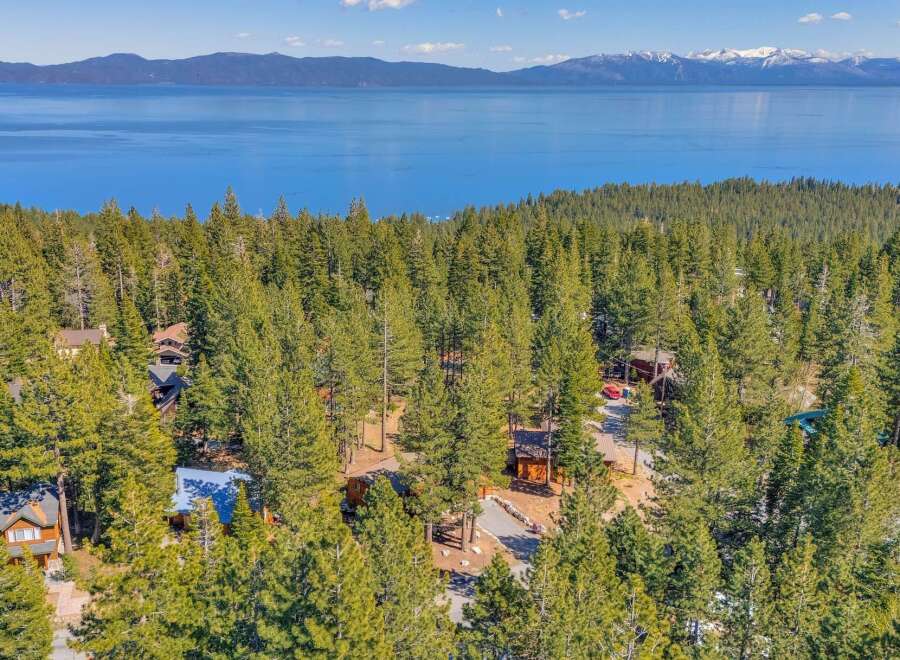 Nestled amidst a lush forest, this property offers a serene escape with stunning views of the lake and mountains.