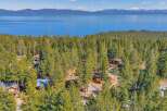 Nestled amidst a lush forest, this property offers a serene escape with stunning views of the lake and mountains.