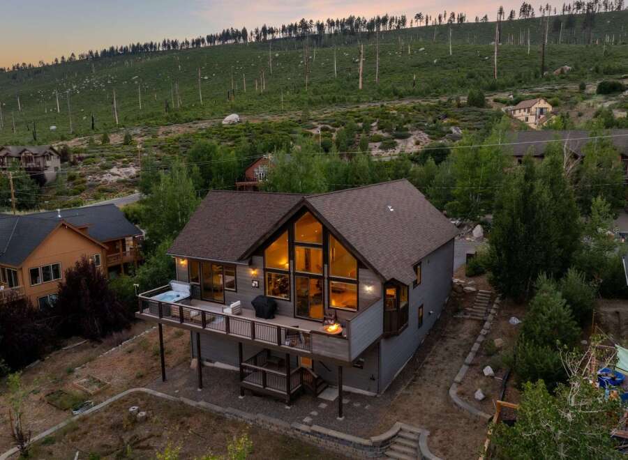 Discover your dream retreat in this stunning mountain home! This property boasts a spacious deck with a hot tub, perfect for enjoying breathtaking views.