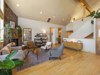 Step into luxury with this stunning property, showcasing a cozy living room with a stone fireplace, perfect for those chilly evenings.